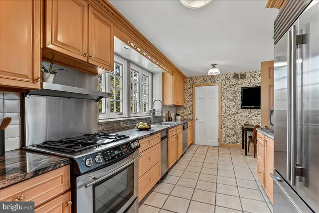 a kitchen with stainless steel appliances granite countertop a sink stove and cabinets