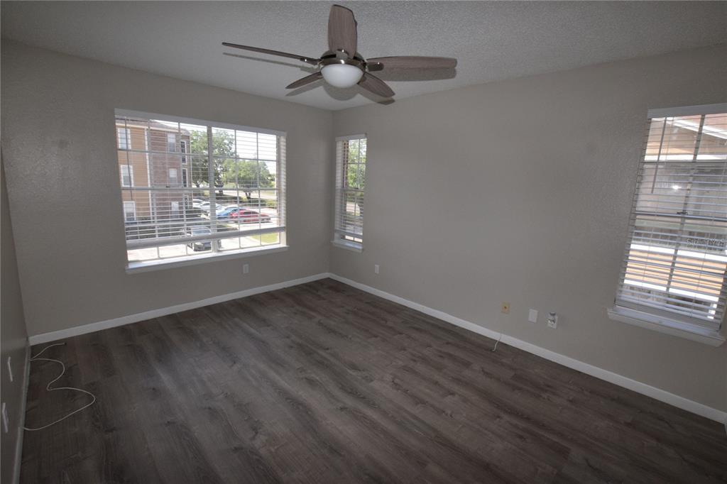 5533 Chrishire Way, Unit F201 Orlando, FL 32822 - Photo 12 of 12 a view of an empty room with wooden floor and a window