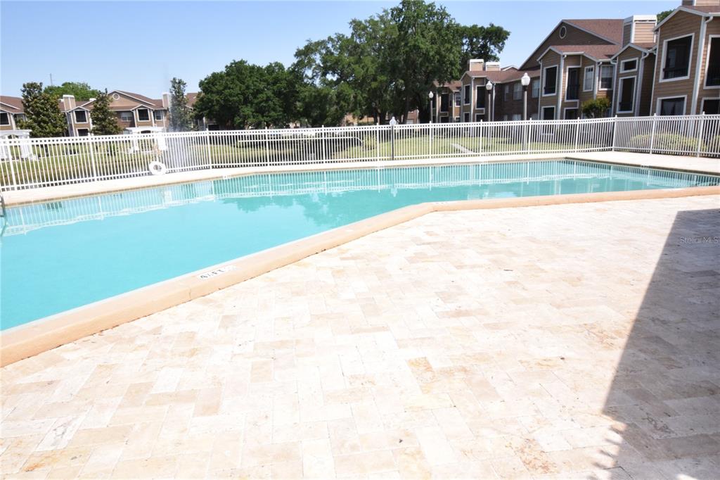 5533 Chrishire Way, Unit F201 Orlando, FL 32822 - Photo 2 of 12 a view of swimming pool that has lawn chairs and a yard
