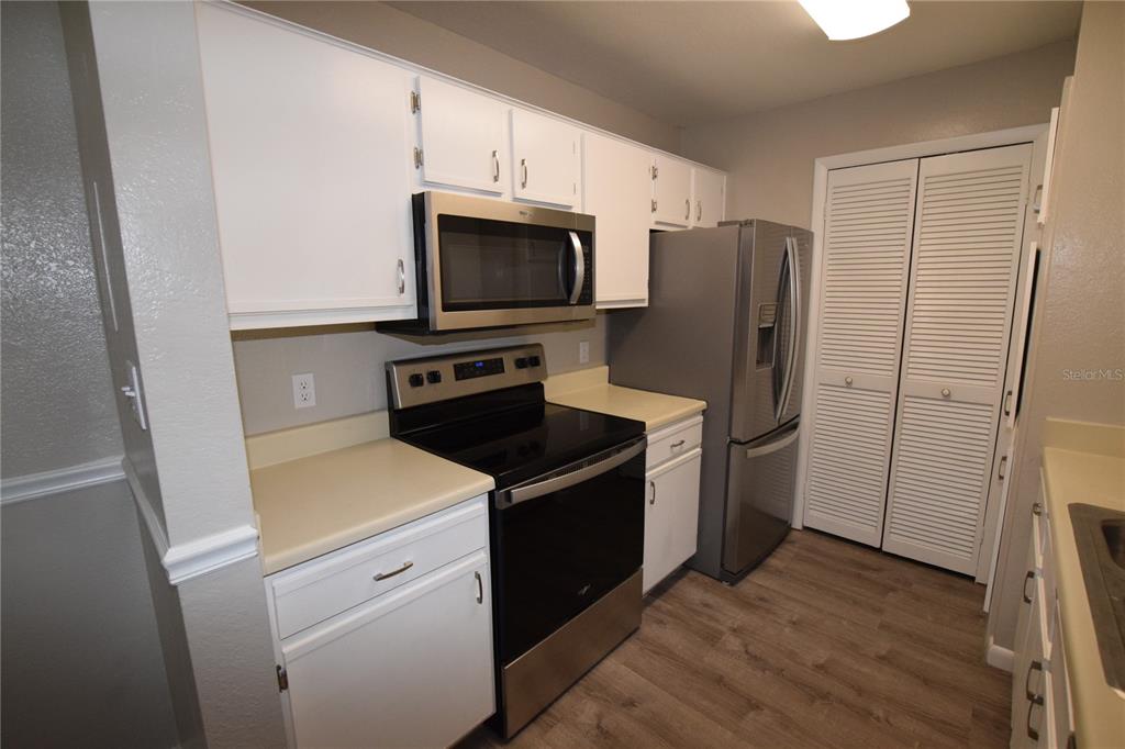 5533 Chrishire Way, Unit F201 Orlando, FL 32822 - Photo 4 of 12 a kitchen with a refrigerator stove and microwave