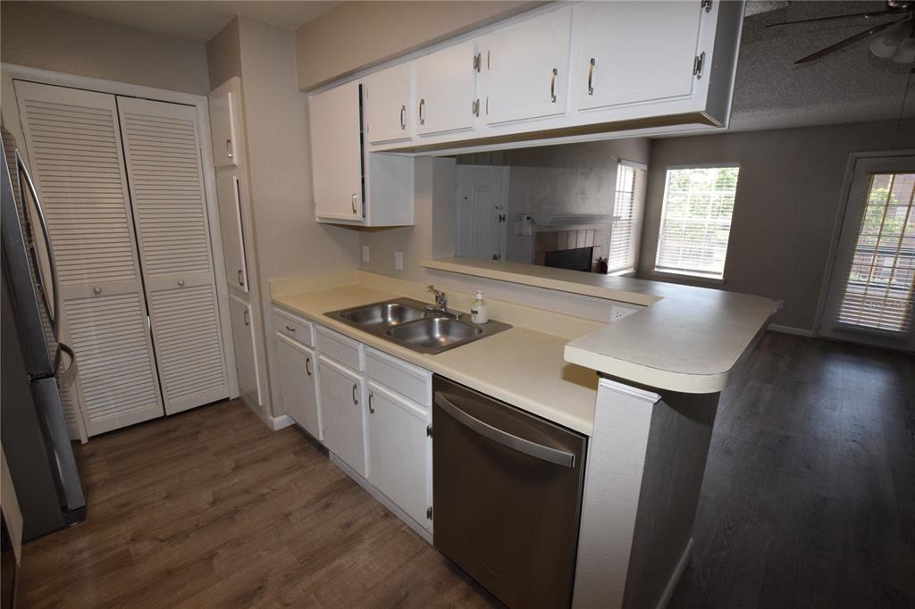 5533 Chrishire Way, Unit F201 Orlando, FL 32822 - Photo 5 of 12 a kitchen with granite countertop a sink cabinets and stainless steel appliances