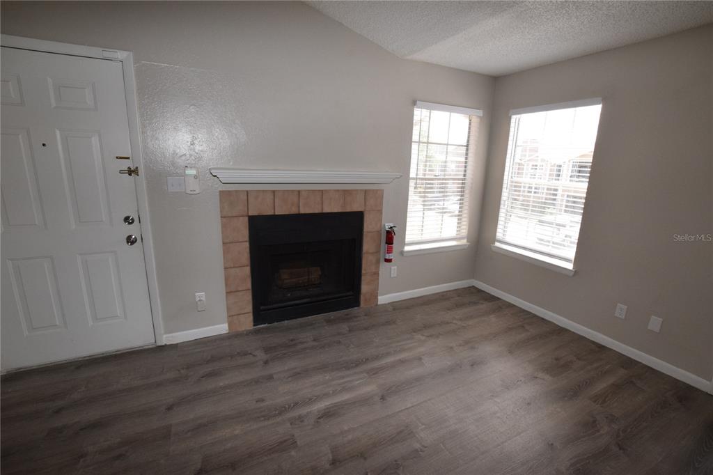 5533 Chrishire Way, Unit F201 Orlando, FL 32822 - Photo 7 of 12 a view of an empty room with wooden floor and a window