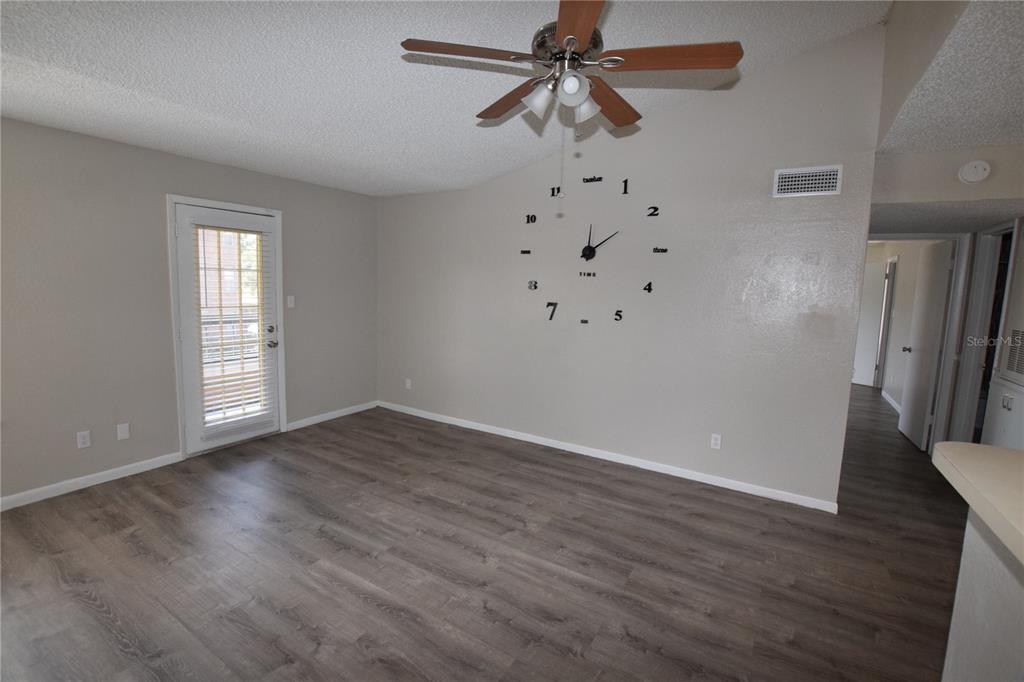 5533 Chrishire Way, Unit F201 Orlando, FL 32822 - Photo 8 of 12 an empty room with wooden floor fan and windows