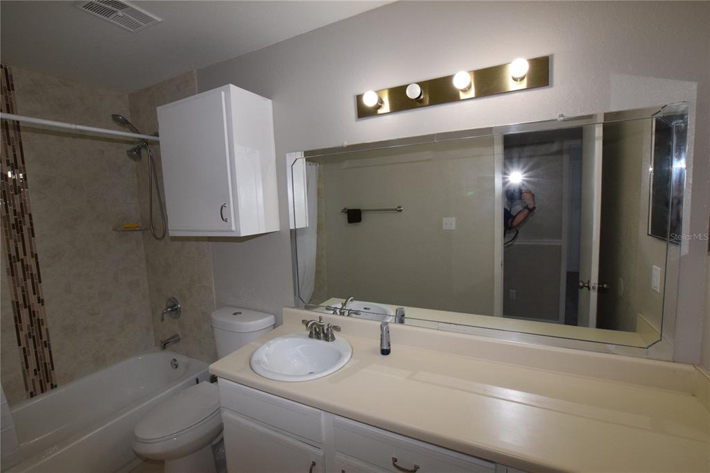 5533 Chrishire Way, Unit F201 Orlando, FL 32822 - Photo 10 of 12 a bathroom with a sink and mirror with toilet