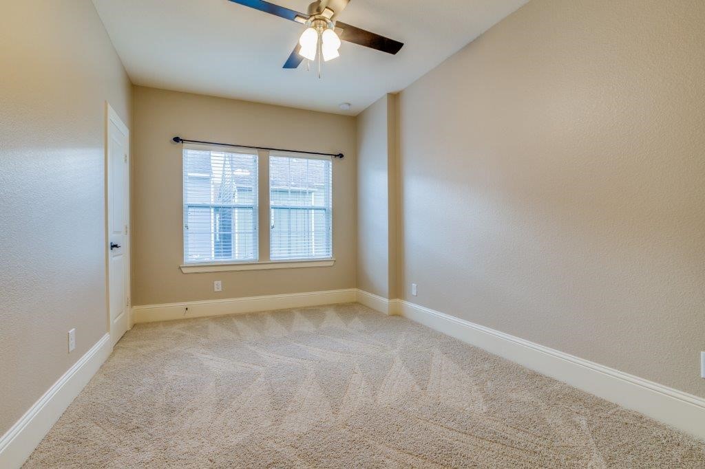 46 East Rafters Row The Woodlands, TX 77380 - Photo 19 of 25 Third bedroom with ceiling fan, large windows, and plush carpeting.
