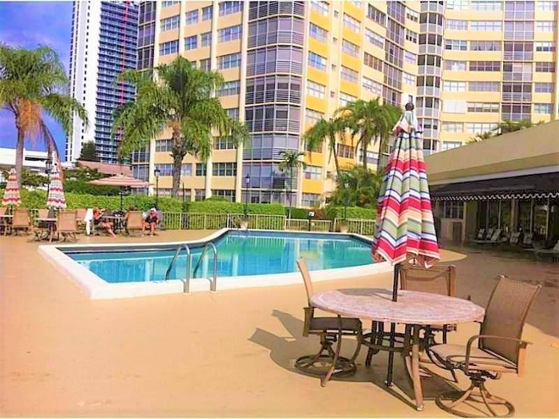 100 Golden Isles Drive, Unit 511 Hallandale Beach, FL 33009 - Photo 16 of 20 a view of a patio with a table and chairs