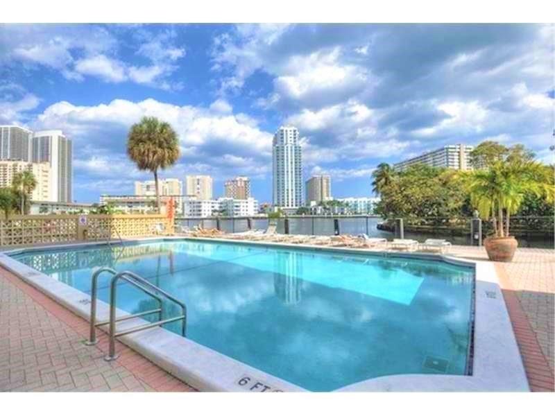 100 Golden Isles Drive, Unit 511 Hallandale Beach, FL 33009 - Photo 17 of 20 a swimming pool with a yard