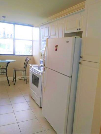 100 Golden Isles Drive, Unit 511 Hallandale Beach, FL 33009 - Photo 4 of 20 a white refrigerator freezer and a stove sitting inside of a kitchen