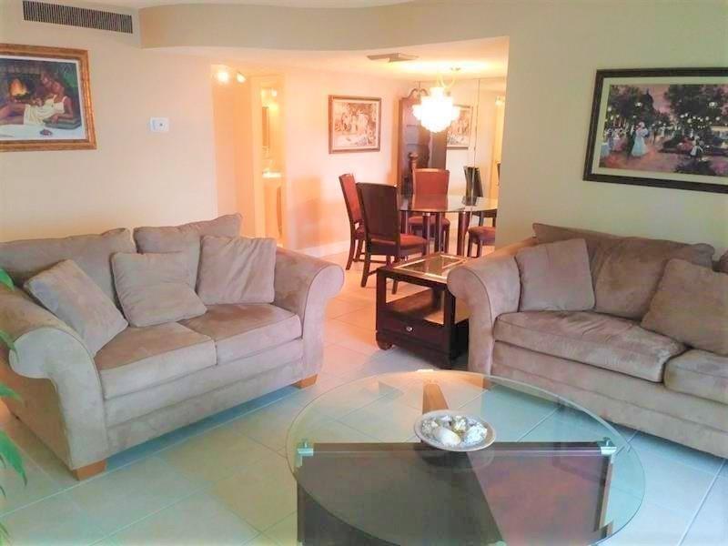 100 Golden Isles Drive, Unit 511 Hallandale Beach, FL 33009 - Photo 5 of 20 a living room with furniture and wooden floor