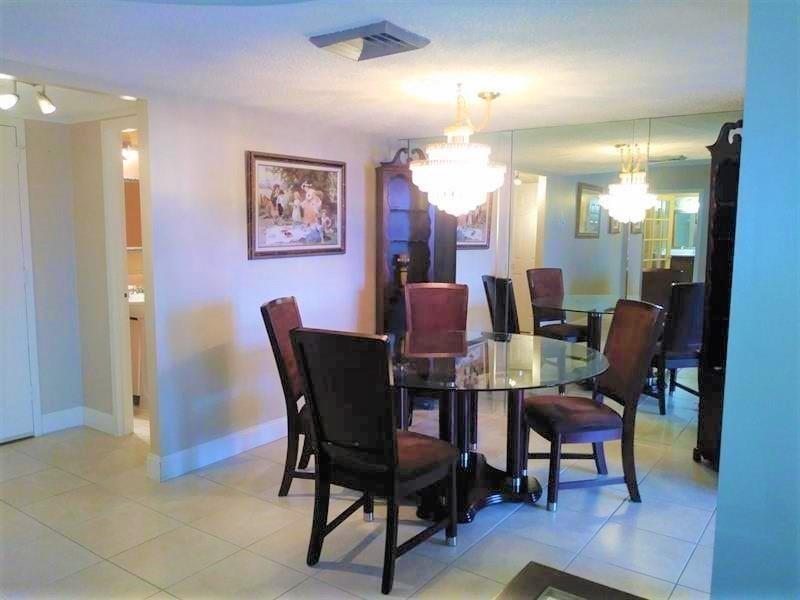 100 Golden Isles Drive, Unit 511 Hallandale Beach, FL 33009 - Photo 7 of 20 a dining room with furniture and wooden floor