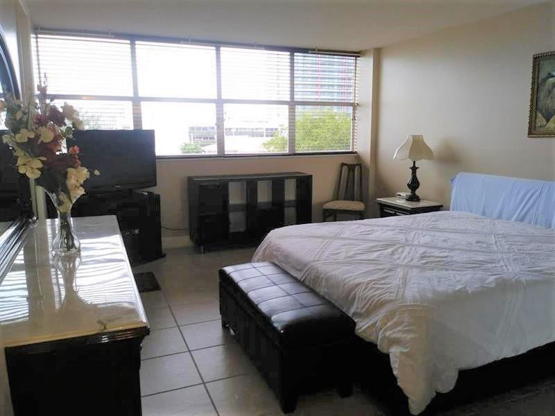 100 Golden Isles Drive, Unit 511 Hallandale Beach, FL 33009 - Photo 8 of 20 a bed sitting in a bedroom next to a window