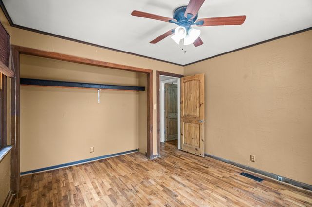 an empty room with a ceiling fan and a window