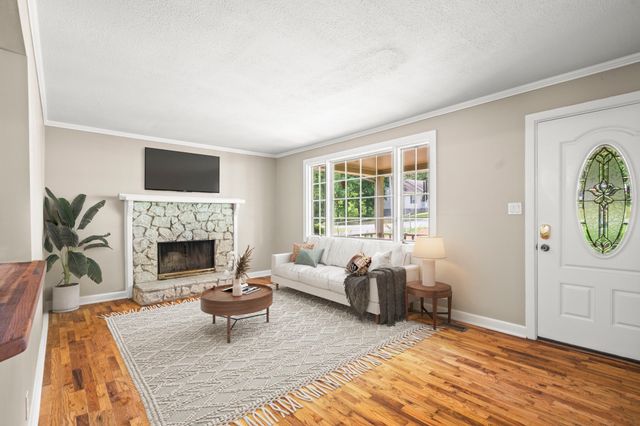 a living room with furniture a window and a fireplace