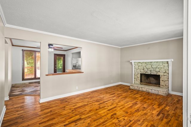 a view of empty room with wooden floor and a fireplace