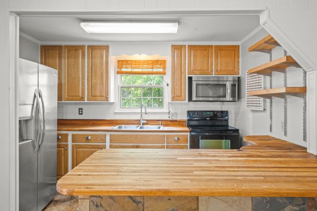 a kitchen with stainless steel appliances a stove sink and microwave