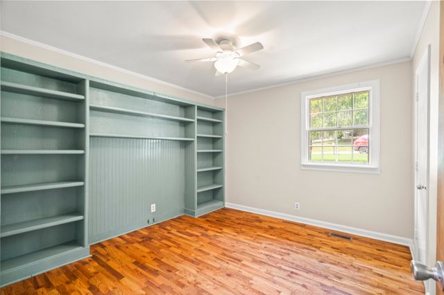 a view of a room with a cabinet and a ceiling fan