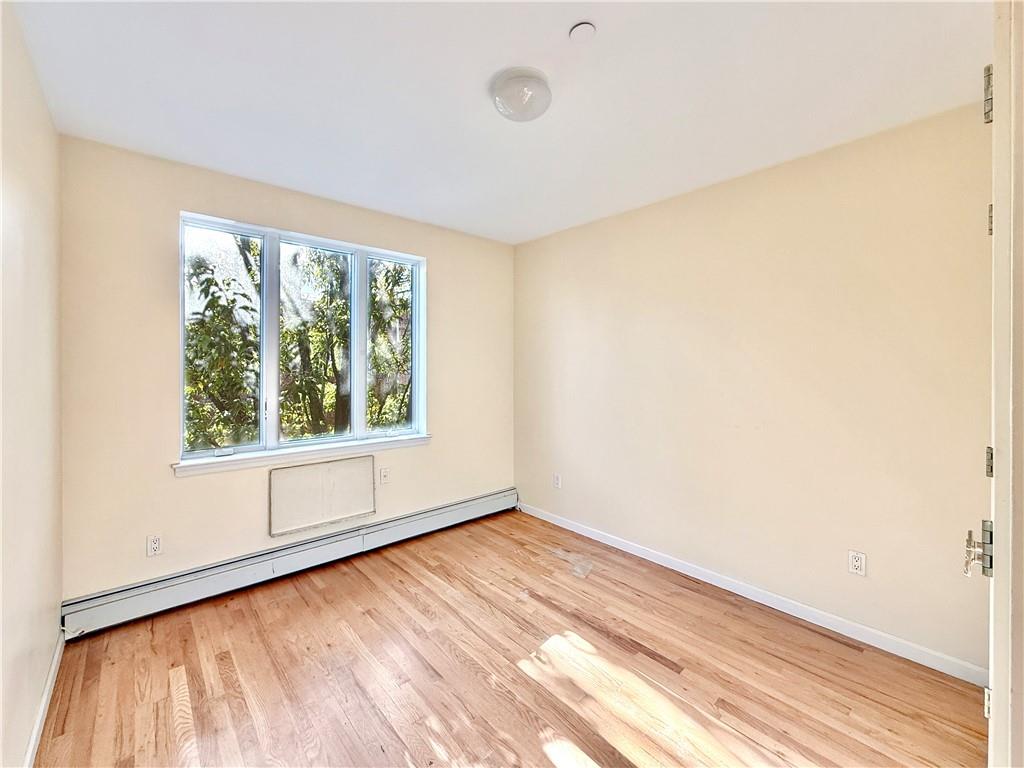 511 68th Street, Unit 2A Brooklyn, NY 11220 - Photo 14 of 19 an empty room with wooden floor and windows