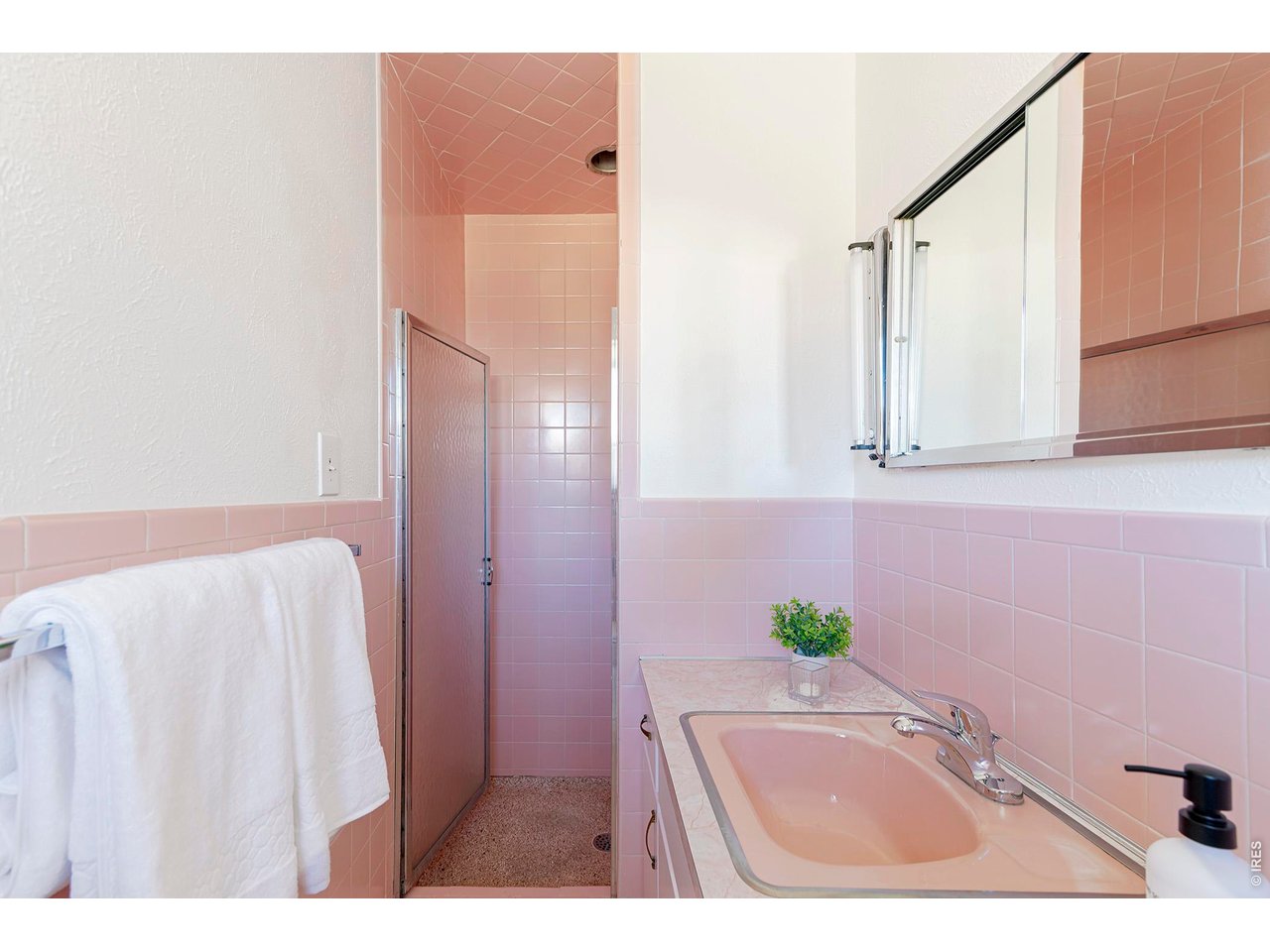 2410 Grape Avenue Boulder, CO 80304 - Photo 21 of 50 This vintage primary bath delights with classic blush tile and a matching pastel sink, capturing the era's signature charm. Original details and soft tones preserve its authentic mid-century character.