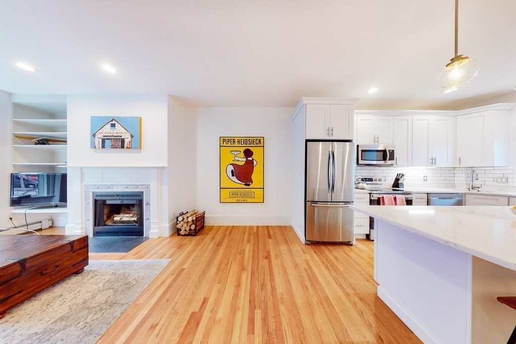 32 Mead Boston Ma, Unit 2 Boston, MA 02129 - Photo 6 of 21 a open kitchen with stainless steel appliances granite countertop a refrigerator stove a oven a sink with island and chairs