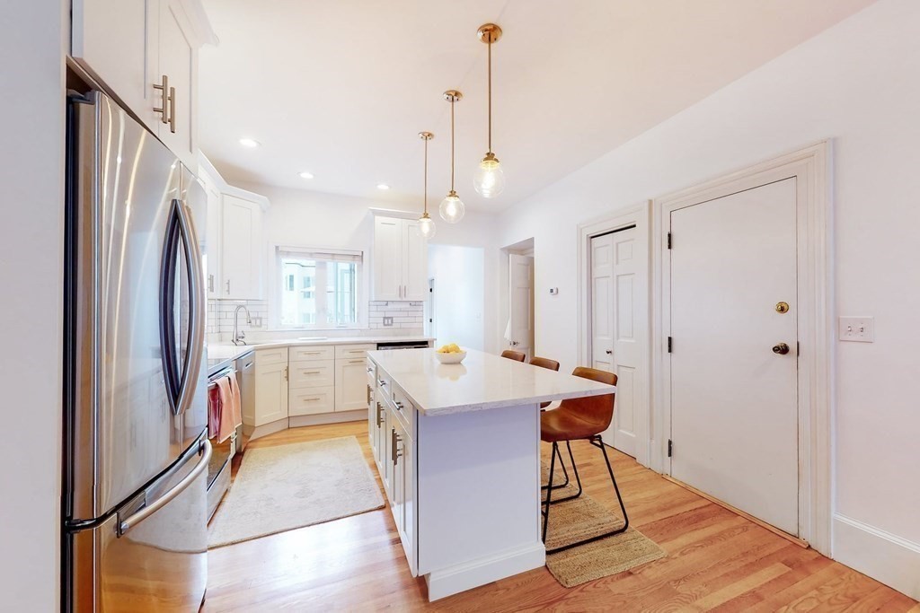 32 Mead Boston Ma, Unit 2 Boston, MA 02129 - Photo 7 of 21 a view of kitchen island with stainless steel appliances granite countertop refrigerator sink and wooden floor