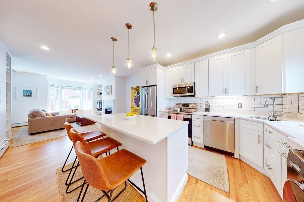 32 Mead Boston Ma, Unit 2 Boston, MA 02129 - Photo 10 of 21 a kitchen with stainless steel appliances kitchen island granite countertop a sink a stove a dining table and chairs