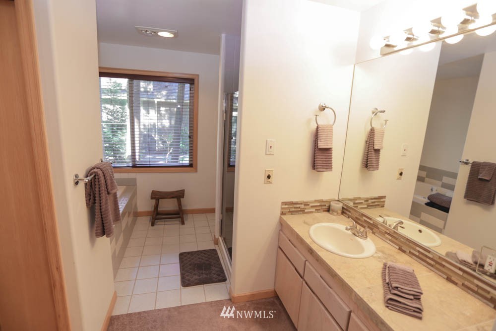 5500 Canvasback Road Blaine, WA 98230 - Photo 22 of 23 a bathroom with a granite countertop sink a mirror and a bathtub