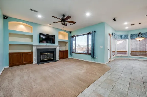 a view of an empty room with a fireplace and a window
