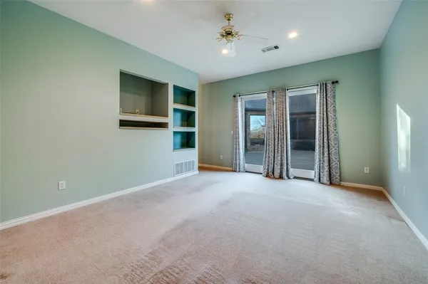 an empty room with windows and cabinet