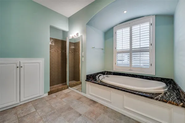 a spacious bathroom with a granite countertop tub and a sink