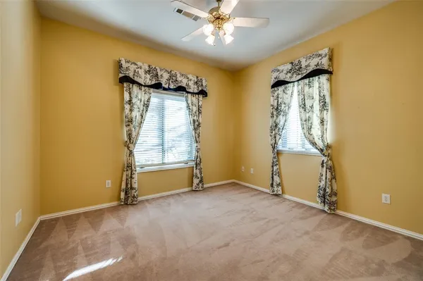 an empty room with a ceiling fan and window
