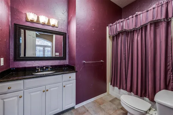 a bathroom with a toilet a sink and mirror