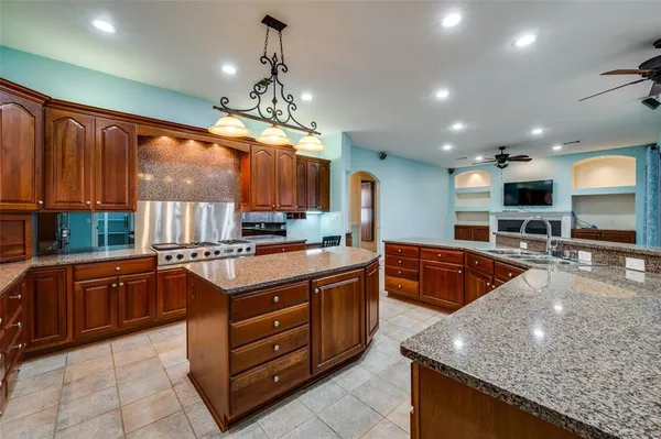 a large kitchen with stainless steel appliances granite countertop a stove and large cabinets