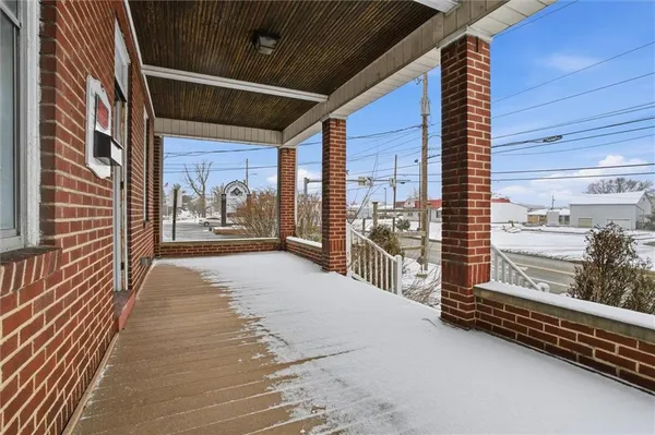 a view of front door and porch with wooden floor