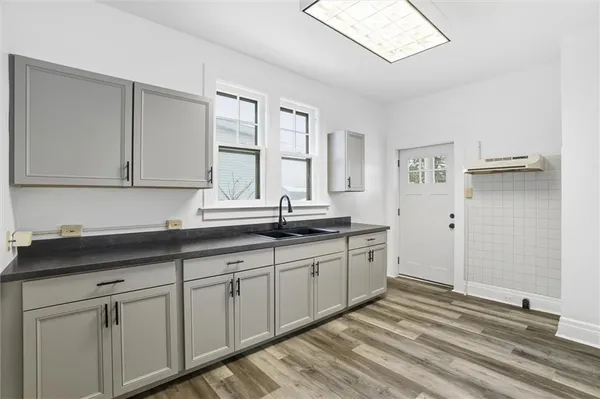 a kitchen with granite countertop white cabinets and a sink
