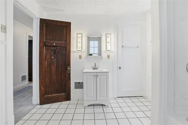 a spacious bathroom with a sink a mirror and a shower