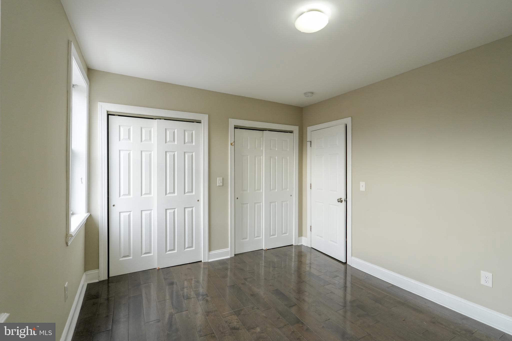2633 Tasker Street Philadelphia, PA 19145 - Photo 13 of 23 an empty room with wooden floor and windows with curtains