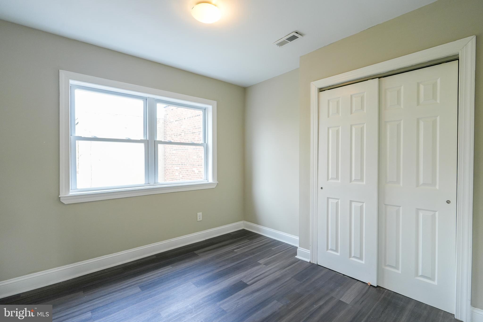 2633 Tasker Street Philadelphia, PA 19145 - Photo 18 of 23 a view of an empty room with wooden floor and a window