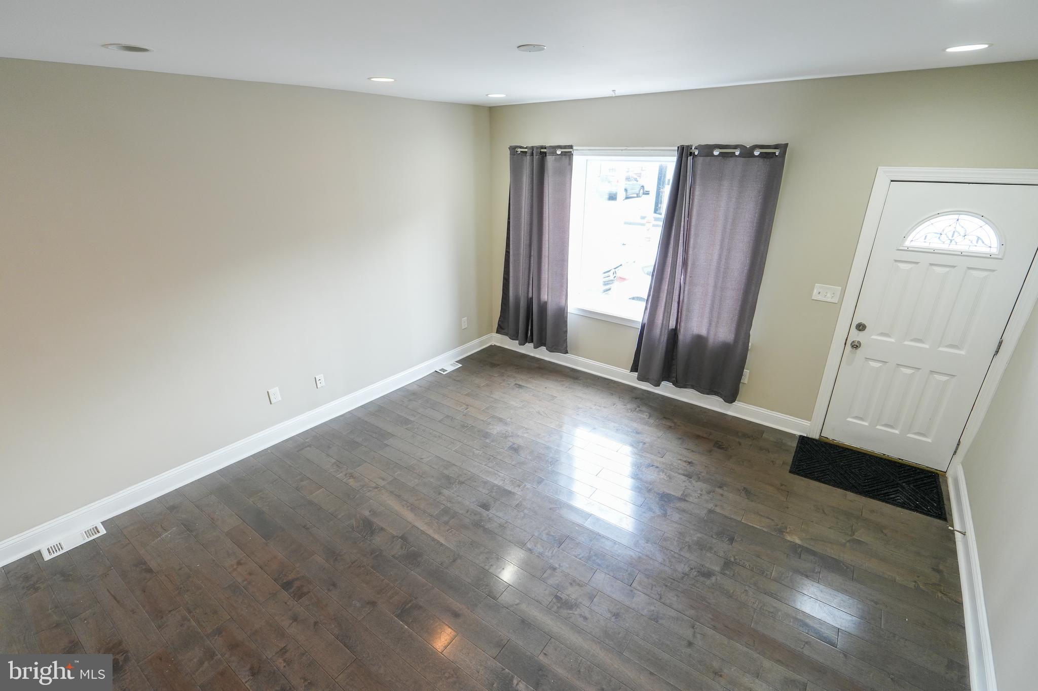 2633 Tasker Street Philadelphia, PA 19145 - Photo 21 of 23 an empty room with wooden floor and a window