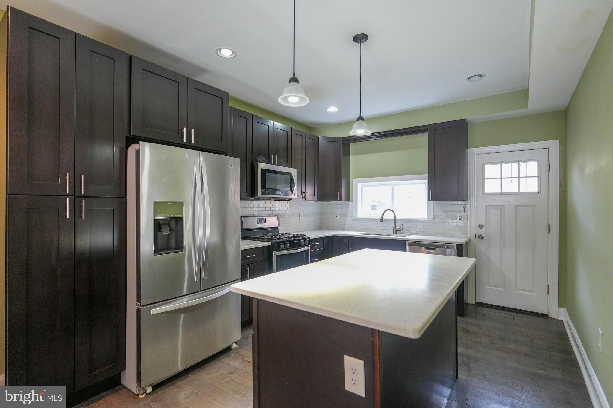 2633 Tasker Street Philadelphia, PA 19145 - Photo 7 of 23 a kitchen with stainless steel appliances a refrigerator sink and microwave