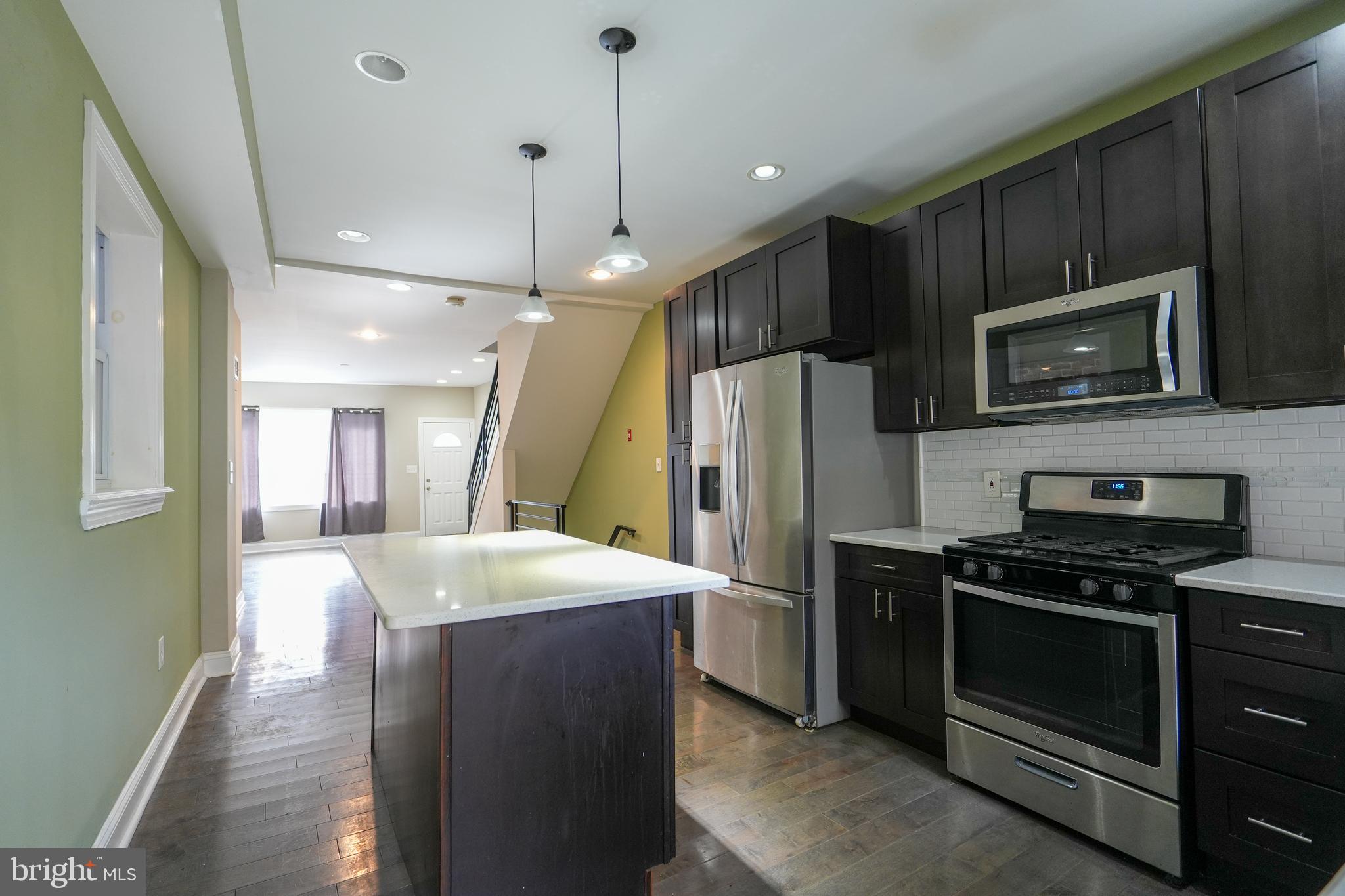 2633 Tasker Street Philadelphia, PA 19145 - Photo 9 of 23 a kitchen with kitchen island a sink stainless steel appliances and cabinets