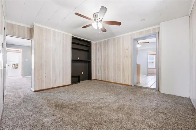 an empty room with closet and a ceiling fan