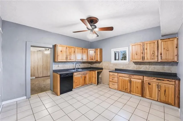 a large kitchen with granite countertop a stove sink and cabinets