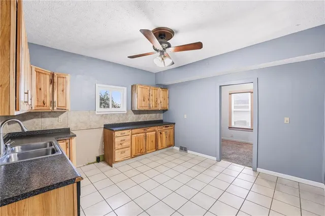 a kitchen with stainless steel appliances granite countertop a sink dishwasher stove and refrigerator
