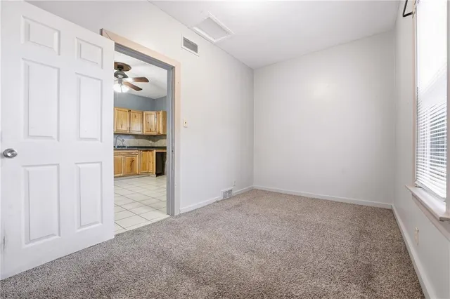 an empty room with closet and windows