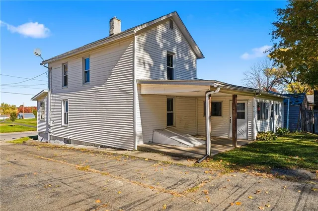 a view of a house with backyard and a tree