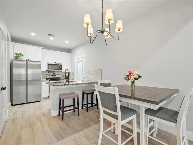 a view of a dining room with furniture and chandelier