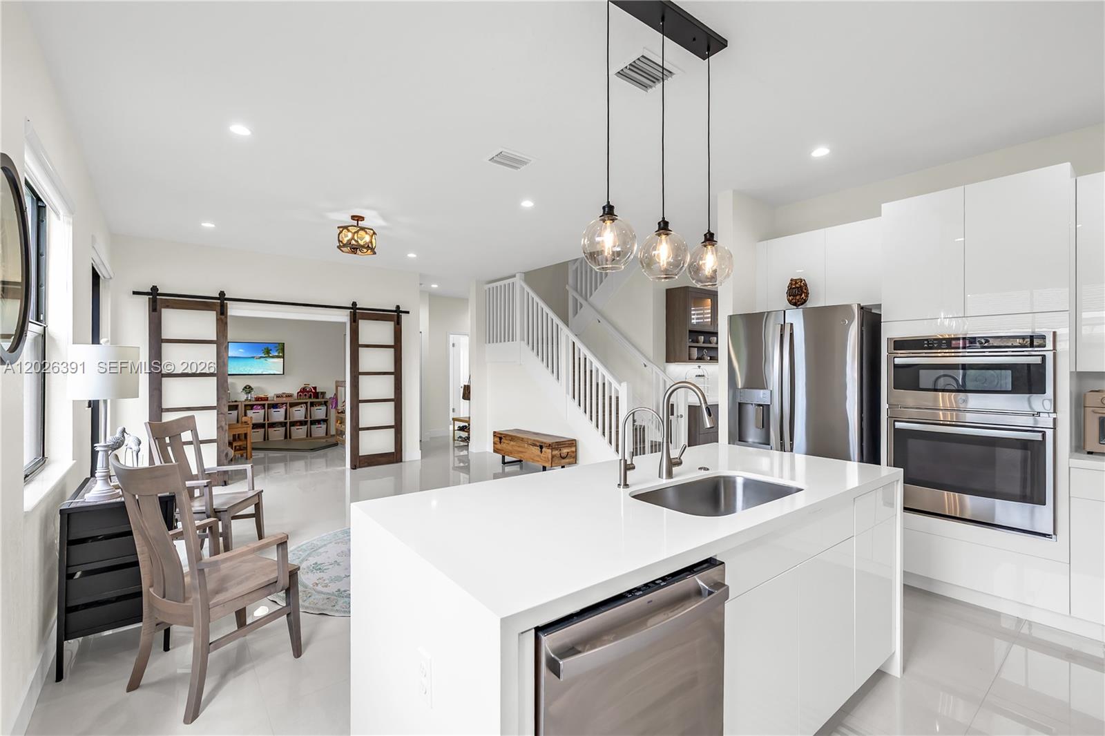 14606 Southwest 22nd Terrace Miami, FL 33175 - Photo 20 of 43 a kitchen with stainless steel appliances kitchen island granite countertop a table chairs and a view of living room