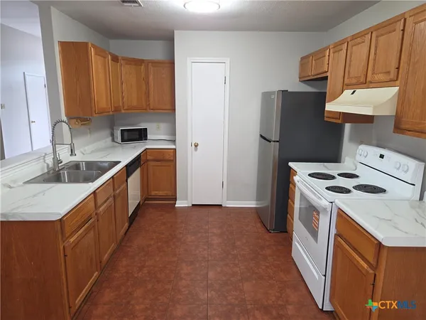a kitchen with a sink a stove and a refrigerator