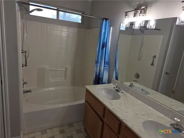 a bathroom with a granite countertop sink a mirror a shower and a bathtub