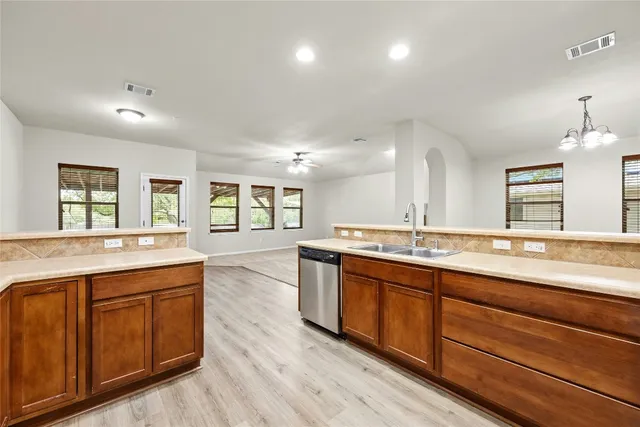 a large kitchen with lots of counter space and wooden floor